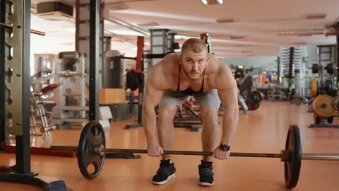 Young white bodybuilder making lifting of the barell to the belt Stock Footage 102229737