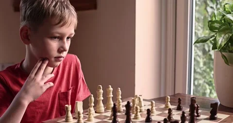Young white child playing a game of chess on large chess board. Stock Footage 232773272