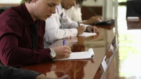 Young white collar worker taking notes in meeting room during conference Stock Footage 10588529