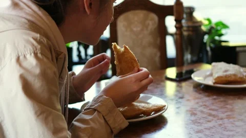 A young white girl eats a deep-fried patty. Stock Footage 282168490