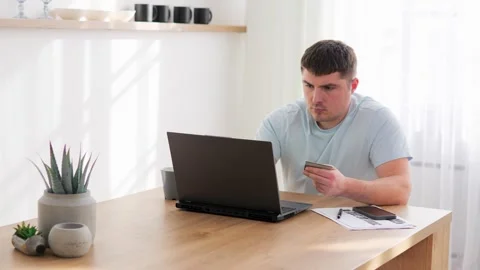 Young white man browsing laptop with credit card in hand, shopping Video stock 266972810