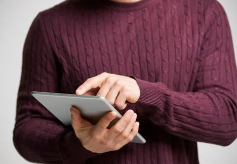 Young white man using a tablet computer, mid section Fotos de archivo