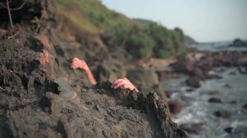 A young white-skinned man with an attractive physical form hardly climbs stones Video stock 234020646