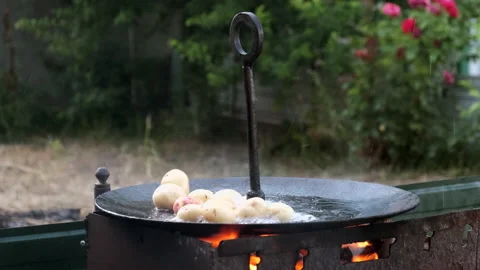 Young whole potatoes fried in boiling oil to a large frying pan. Stock Footage 135767599