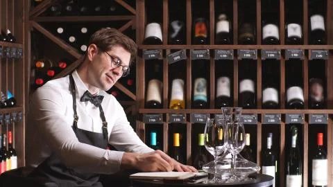 Young wine critic makes notes in his notebook about the quality and sediment of Stock Photos