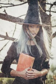 Young witch with book Stock Photos