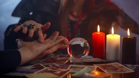 Young witch fortune teller reading fortune lines on male palm or hand, mystic Stock Footage 132101776