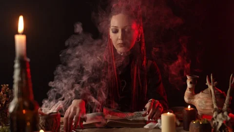 Young witch with knife reading magic book 스톡 동영상 127830797