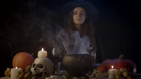 Young witch looking at steaming cauldron Stock Footage 141293512