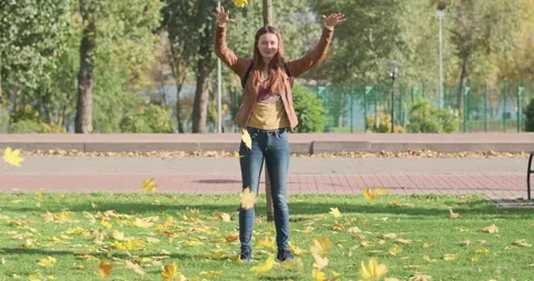 Young witch makes time go backwards. Autumn yellow leaves fly upwards Stock Footage 258608236