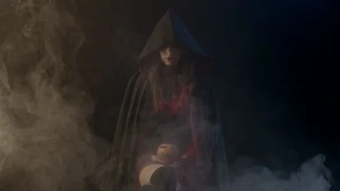 Young witch with pumpkin on lap Stock Footage 142033101