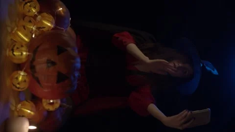 Young witch with skull and pumpkins Stock Footage 140860148
