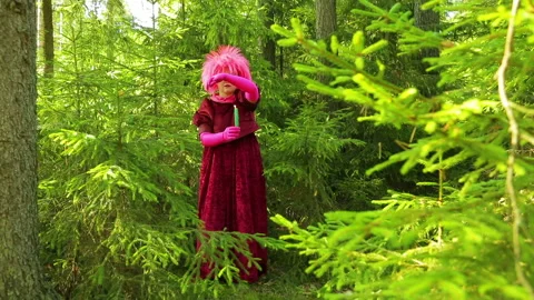 A young witch in a spruce forest is casting a spell over a candle that she holds Stock Footage 96306265