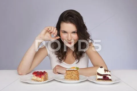 Young woman with 3 plates of cake, portrait Stock Photos
