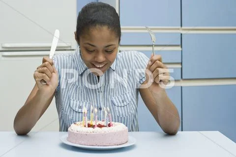 A young woman about to eat a birthday cake Stock Photos