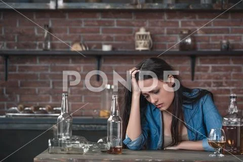 Young woman alcoholic social problems concept sitting looking down drunk Stock Photos