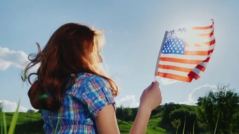 Young woman with the American flag in the sun Stock Footage