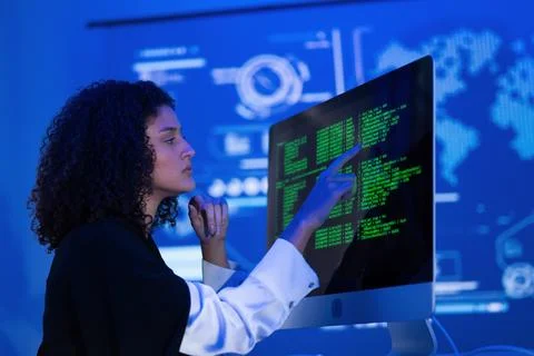 Young woman analyzes data on computer screen in a high-tech office setting .. Foto stock