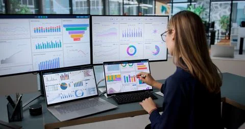 Young Woman Analyzing Financial Data And KPI Dashboard On Laptop. Stock Photos