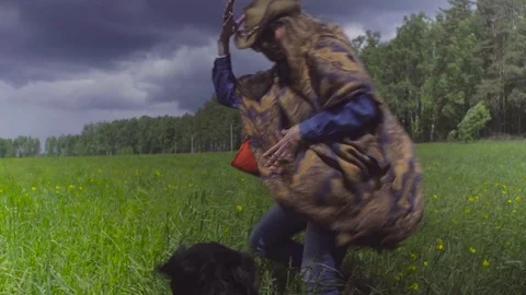Young woman and a dog running on a field Stock Footage