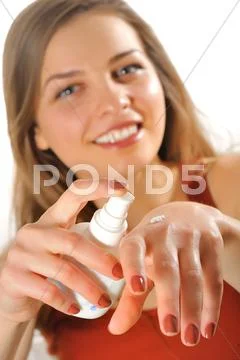 Young woman applies cream on her hands Stock Photos