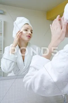 Young woman applying beauty cream Stock Photos