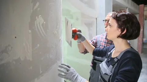 Young woman apprentice with professional plasterer Stock Footage 51560839