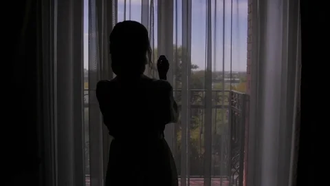 A young woman approaches the window, opens to a balcony, enjoying. morning bride Stock-Footage 81691055