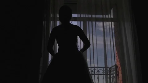 A young woman approaches the window, opens to a balcony, enjoying. morning bride Vídeos de archivo 81937822