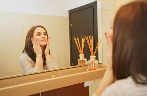 Young woman arranging herself in the bathroom in the morning Stock Photos