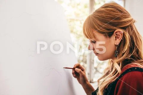 Young woman artist drawing with pencil Stock Photos