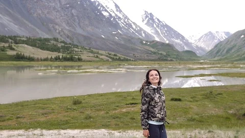 Young woman on the background of the mountains runs and dances. traveler Vídeos de archivo 105336953