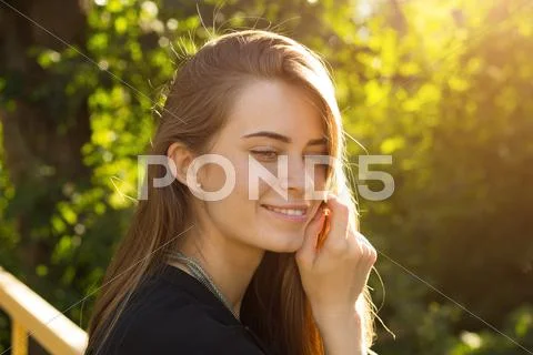 Young woman on the background of trees and sunlight Stock Photos