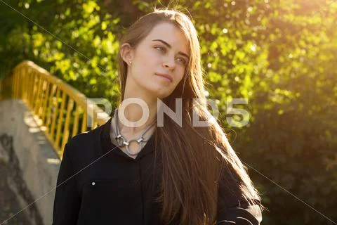 Young woman on the background of trees and sunlight Stock Photos