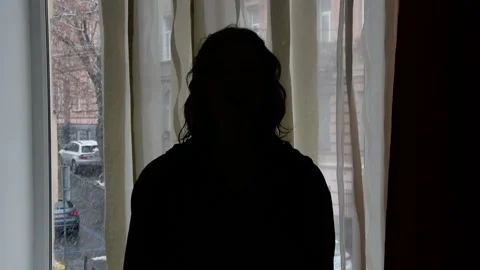 A young woman on the background of a window in the background light tells a stor Video stock 172283904