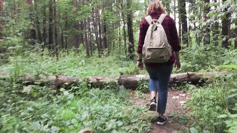 A young woman with a backpack is walking the path at the forest. Stock Footage 94070927