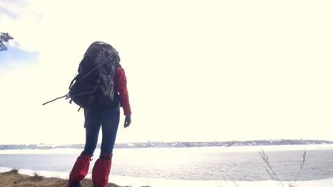 Young woman with backpackat the cliff . Back view. Travel sport lifestyle Stock Footage