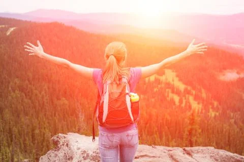 Young woman backpacker at mountain top. Happy and cheering concept Stock Photos