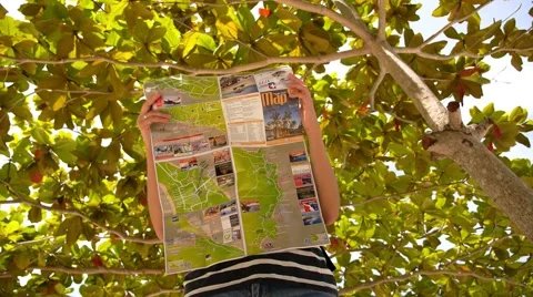 Young Woman Backpacker Reading Map on the Beach. Slow Motion. Stockbeeldmateriaal 42671932
