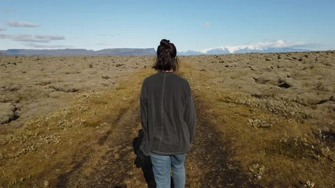 Young woman backpacker walking through spectacular lava fields covered in green  Stock Footage 116029694