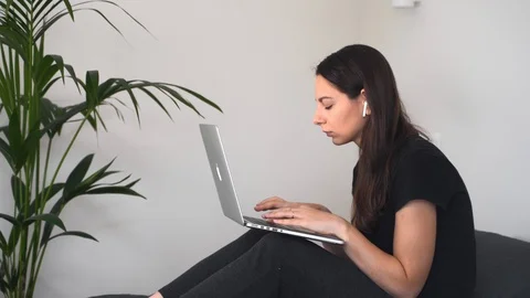 Young woman with bad posture working from home on her laptop. Using laptop in Stock Footage 127166554