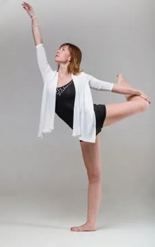 Young woman ballerina ballet dancer dancing on gray background Stock Photos