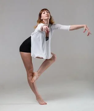 Young woman ballerina ballet dancer dancing on gray background Stock Photos