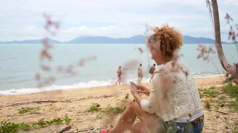 Young Woman at Beach Using Cellphone Видео 40729295