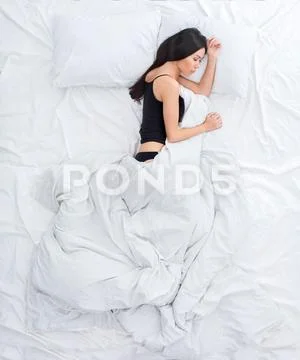 Young woman on bed top view rest concept sleeping on side Stock Photos