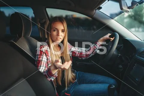 Young woman beginner offers a ride on car Stock Photos