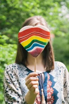 Young woman behind a big colorful lollipop Stock Photos