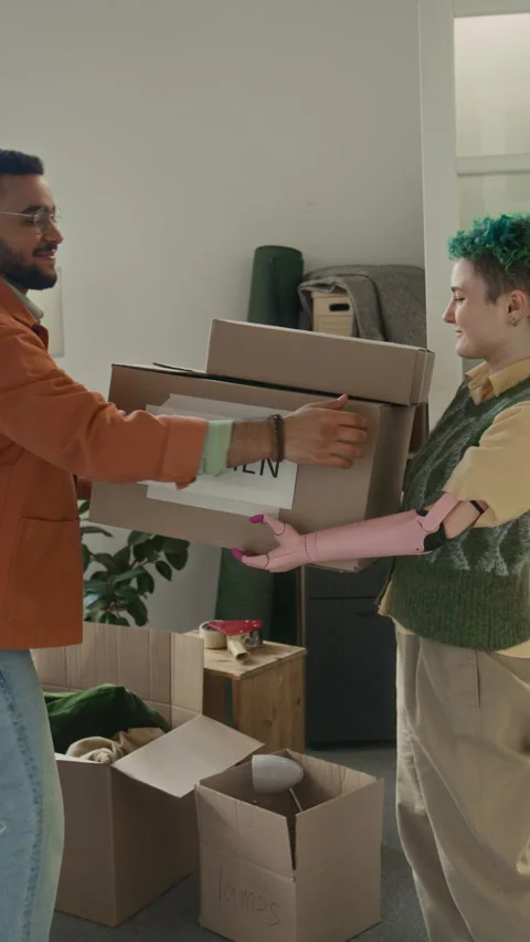 Young Woman with Bionic Arm Giving Two Moving Boxes to Positive Boyfriend 스톡 동영상 323310514