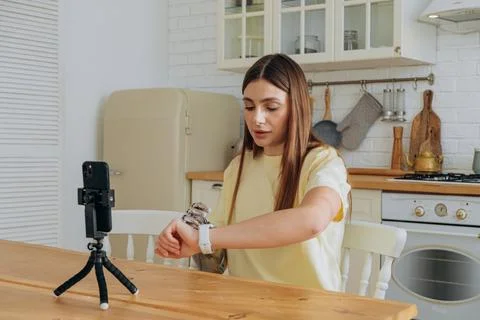 Young woman with a bionic hand and smartwatch recording a video for her online Stock Photos