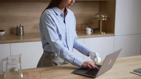 Young woman with bionic hand is typing on laptop and working at table at home Stock Footage 197747101
